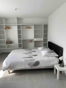 een slaapkamer met een groot bed en planken bij Propriete de 3 chambres avec terrasse et wifi a Quetigny in Quétigny