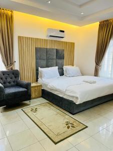 a bedroom with a large bed and a chair at Diaggello Homex Apartment in Lekki