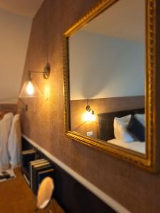 a mirror on a wall in a hotel room at Chambres d'hôtes - Au Clos d'Amande in Lasne