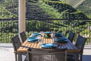 a wooden table with blue napkins and plates on it at Villa Carrillos, 365-rentals in Benamargosa