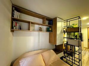 a bedroom with a bed and a book shelf at Loft between best business centers & restobars in Bogotá