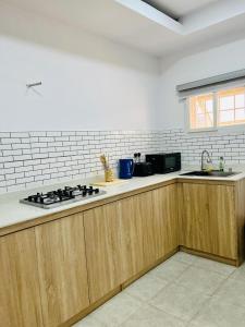 a kitchen with wooden cabinets and a stove top at Diaggello Homex Apartment in Lekki