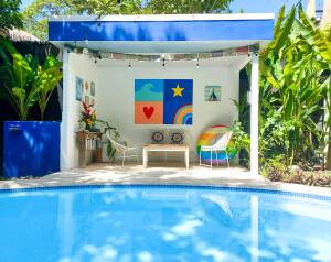 una casa junto a la piscina con mesa y sillas en Calma Apartments Costa Rica, en Mal País