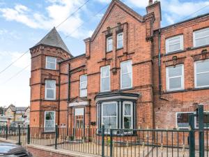 an old red brick building with a black fence at 7 Bed in Bridlington 90787 in Bridlington