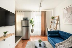 a living room with a blue couch and a refrigerator at 69-4D Trendy Lower East Side 1B BRAND NEW in New York