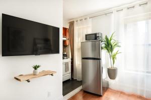 a kitchen with a refrigerator and a tv on a wall at 69-4D Trendy Lower East Side 1B BRAND NEW in New York