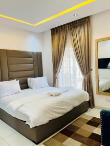 a bedroom with a large bed in front of a window at Diaggello Homex Apartment in Lekki