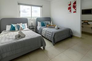 una camera da letto con due letti e una finestra di Exclusive building 6 people 3 cable televisions 3 swimming pools balcony, a Cancún Altre 53 foto