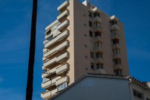 ein hohes Gebäude mit Balkonen an der Seite in der Unterkunft Apartamento Aloha Torres (La Carihuela) Torremolinos in Torremolinos
