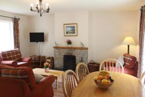 sala de estar con mesa y chimenea en Leitrim Quay - Riverside Cottage 6, en Leitrim