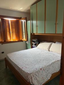 ein Schlafzimmer mit einem Bett und einigen Holzschränken in der Unterkunft Casa vacanze a Budoni in Budoni