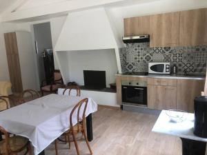 a kitchen with a table and chairs and a microwave at Propriete d'une chambre avec piscine partagee et wifi a Saint Gilles in Saint-Gilles