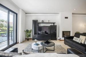 ein Wohnzimmer mit einem Sofa und einem TV in der Unterkunft Til Home by Madeira Sun Travel in Funchal