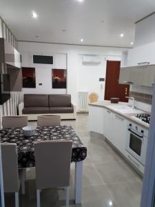 uma cozinha e sala de estar com mesa e cadeiras em La Vela Apulia Seaside Residence em Margherita di Savoia