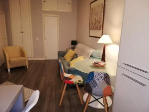 ein Wohnzimmer mit einem Sofa, einem Tisch und Stühlen in der Unterkunft 2 bedrooms apartement with wifi at Sevilla in Sevilla