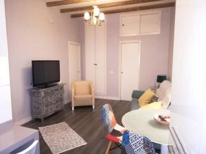 ein Wohnzimmer mit einem TV und einem Tisch in der Unterkunft 2 bedrooms apartement with wifi at Sevilla in Sevilla