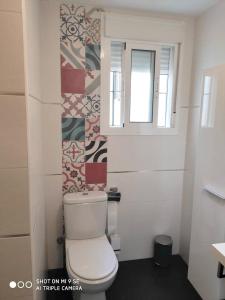 ein kleines Bad mit einem WC und einem Fenster in der Unterkunft 2 bedrooms apartement with wifi at Sevilla in Sevilla