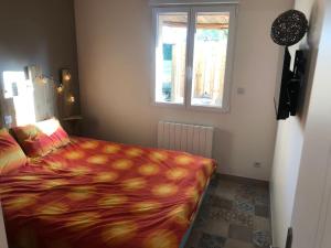 une chambre avec un lit avec une couverture dessus dans l'établissement Chalet charmant à Clermont-Créans avec piscine partagée, à La Flèche 29 autres photos