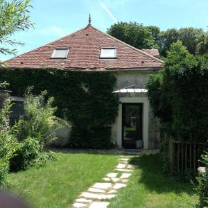 una casa con una porta coperta d'edera e un cortile di Propriete d'une chambre avec terrasse et wifi a Essomes sur Marnea a Essômes-sur-Marne