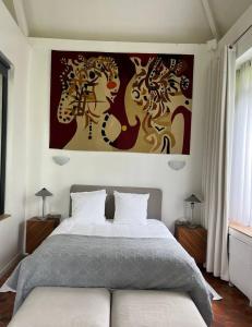 una camera da letto con un letto e un dipinto sul muro di Propriete d'une chambre avec terrasse et wifi a Essomes sur Marnea a Essômes-sur-Marne