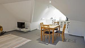 uma sala de jantar com mesa e cadeiras e uma televisão em Marthas Insel em Oldenswort