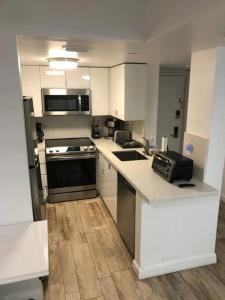 a kitchen with white cabinets and a counter top at BEST DEAL! 2 Bedroom Modern Beachfront by YouRent! in Miami Beach
