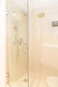een douche met een glazen deur naast een wastafel bij BEST DEAL! 2 Bedroom Modern Beachfront by YouRent! in Miami Beach