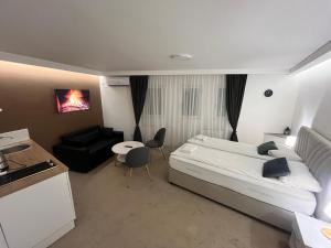 um quarto com uma cama, um sofá e uma mesa em Guest House LIKE em Saraievo