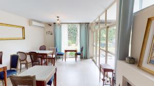ein Esszimmer mit Tischen, Stühlen und Fenstern in der Unterkunft BENS L'Hôtel Palermo in Buenos Aires