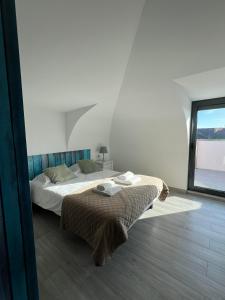 uma cama num quarto com uma grande janela em YEY Baleal em Peniche