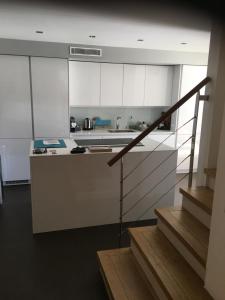 cocina con armarios blancos y encimera en VILLA DE LUXE A PORT GRIMAUD, en Grimaud