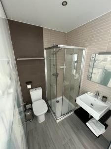 uma casa de banho com um chuveiro, um WC e um lavatório. em YEY Baleal em Peniche