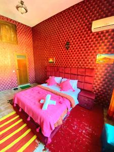 a bedroom with a pink bed with a cross on it at Dar Merzouga Meknes in Meknès