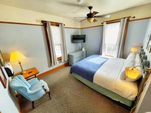 a bedroom with a bed and a chair and a tv at Hotel Vendome in Prescott