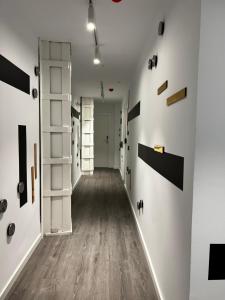 Apartamento Blanco hasta 6 personas في أليكانتي: ممر فارغ بجدران بيضاء وارضيات خشبية