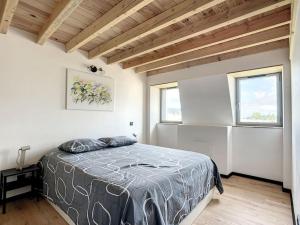 een slaapkamer met een bed en 2 ramen bij Appartement d'exception, terrasse vue Pic du Midi in Bagnères-de-Bigorre