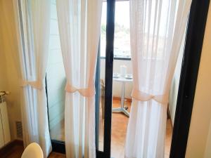 a window with curtains in a room with a table at HIKARI, centro Luanco con PARKING in Luanco