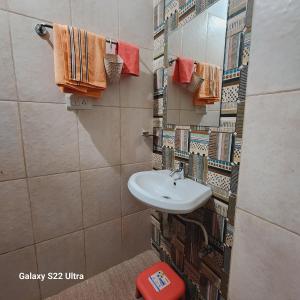 y baño con lavabo, espejo y toallas. en Om Villa, en Bhopal