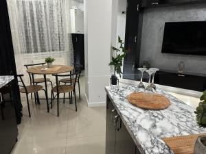 een keuken met een aanrecht met een tafel en stoelen bij New Eva Unique Luxury Apartament in Mamaia Nord – Năvodari