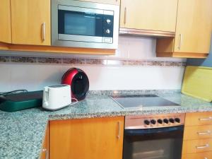 a kitchen counter with a toaster and a microwave at HIKARI, centro Luanco con PARKING in Luanco +16 photos