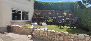 a backyard with a stone wall and a table and chairs at Ferienwohnung MIA in Flußbach