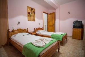two beds in a room with a tv and a tv at Elea Houses in Mithymna