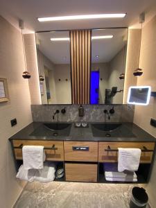 a bathroom with two sinks and a large mirror at Hotel Tirol in Ischgl