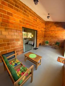 a room with a brick wall and a table and chairs at Pousada Pitauá in Socorro