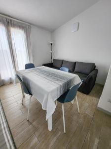 a living room with a table and a couch at L'Attico Blu - Affitti Brevi Italia in Valledoria