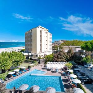 un hôtel avec une piscine et une plage dans l'établissement Hotel Colorado Cesenatico, à Cesenatico