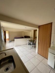 a kitchen with a table and chairs in a room at Kitnet agradável Alto Caparaó MG in Caparaó Velho