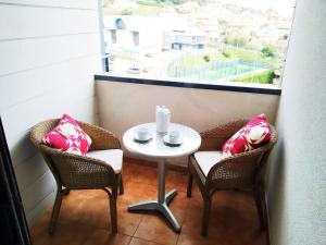 a table and two chairs with a table and a window at HIKARI, centro Luanco con PARKING in Luanco