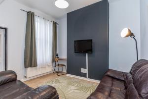a living room with a couch and a flat screen tv at Castlereagh guest House in Belfast