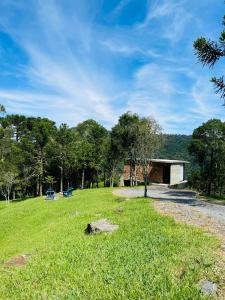 uma casa no meio de um campo relvado em Cabana Efatah - Pousada Colina dos Ventos em Urubici